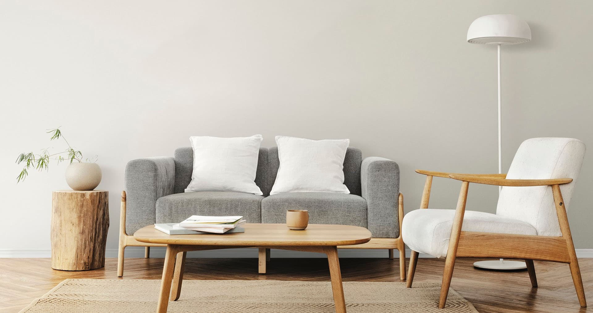 salon nordique avec canapé, table base, fauteuil et lampe sur pied